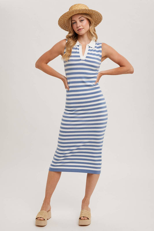 Woman wearing a blue and white striped dress with a straw hat on a plain background